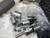Clear bag of metal fittings with black rubber stoppers beside a printed sheet