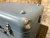 Corner of the blue case with chipped paint, a latch and a dome foot