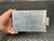 PolyPhaser surge protector showing aluminum casing with moderate surface scratches and wear. Mounting bracket attached, screws intact.