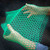 Hands pulling apart a sheet of green Poly-Net HDPE Protective Mesh Netting Tube from Obtainium Science and Surplus to show flexibility.
