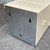 Bare steel rear panel with three keyhole mounting slots; cream painted enclosure with ventilation perforations on top; no visible wear or damage.