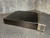 Black amplifier chassis from the side with front handle on diamond plate