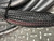 Black braided jacket with red tracer threads intact, braid weave uniform with no fraying; cable bundled with zip tie, consistent with pull-ready configuration.