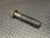 Unused hex bolt with intact knurled grip section; hex head shows no rounding, threads and shank surface clean with no corrosion.