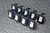 Nine black rocker units arranged in rows; white rockers labeled ON/OFF visible, blue accent color on bodies. No visible wear or damage.