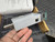 Hand holding gray scanner module showing a modular jack and coaxial connector