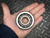 Timken 41106 taper roller bearing assembly held in a hand for scale against a diamond plate background.