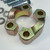 Two thick yellow zinc Code 62 clamp halves with bolts and lock washers behind
