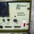 A detailed closeup of the control panel for a Dimetrics Centaur 75 TIG Welder, likely models 7001 or 7008, specifically the SEQUENCE CONTROLLER unit. This industrial orbital welding equipment features an olive green chassis with a creamcolored front panel displaying the Centaur logo and text "DIMETRICS inc. MADE IN U.S.A.". Visible controls include a digital timer/counter, toggle switches for "AUTO", "MAN WELD TIME", and "MAN WATER", along with a "POST PURGE" rotary knob adjustable up to 10 seconds. Multiple Dsub connectors are present, labeled "REMOTE OUT" and "REMOTE IN", essential for connecting an automated welding system. A red "AC POWER" rocker switch clearly indicates "ON" and "OFF" positions, complementing various status indicator lights, all designed for precise welding machine operation.