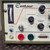 Detailed view of the Dimetrics Centaur 75 TIG Welder 7001 7008 orbital welding machine control panel, featuring a light cream faceplate and olive green casing. The panel displays an analog current meter from 075 amps, digital readout knobs for Weld Current (16.6 amps), Low Pulse Width (5.0%), and Background Current (19.0 amps). It includes a 010 second Upslope adjustment knob, blue Sequence Start button, and yellow Sequence Stop button. Key output connections are a red Electrode terminal, green Ground terminal, and a Remote Out port, ideal for precision TIG welding applications.