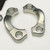 Close view of two bright metal split flange clamp halves with bolt holes