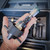Hand holding a black and silver metal tool with adjustment knobs, above the open foam-lined toolbox. Conval TK5D-C-S-1 Tool Kit for Size 5D Valves from Obtainium Science and Surplus.