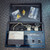 Open case containing a Thermal Engineering 14571 Dual Power Thermistor Vacuum Gauge with Sensor from Obtainium Science and Surplus, showing the gauge, wires, and included brass fittings.