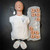 Simulaids manikin wearing white T-shirt with "SIMULAIDS Woodstock, NY" logo, showing light wear. Ten replacement face pieces and two AED training pads included.