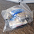 Plastic bag containing L-com connectivity products and fittings, likely accessories for the Hoffman enclosure.