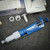Blue and white VWR Ergonomic High-Performance pipettor beside two white rings and a tool