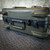 Olive green hard case exterior showing surface scuffs and wear. Combination lock mechanism is defeated and non-functional.
