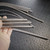 Multiple flexible SS conduit wire guides fanned out; interlocked spiral wrap intact, minor surface patina, bare wire tips visible at ends.