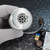 Brushed aluminum sensor housing with louvered diffusion face and central aperture; connected cable leads to PCB with ZERO, SPAN trimmers and 7-pin receptacle visible.