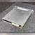 Brushed aluminum enclosure with light surface scratching across the top face. NI label with barcode visible upper right. Multi-pin connector and white keyed connector exposed at bottom edge.