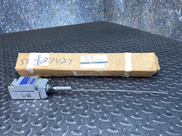 Unit partially removed from original kraft cardboard box, handwritten inventory tag "SS7427" visible. Switch body and spring rod actuator intact.