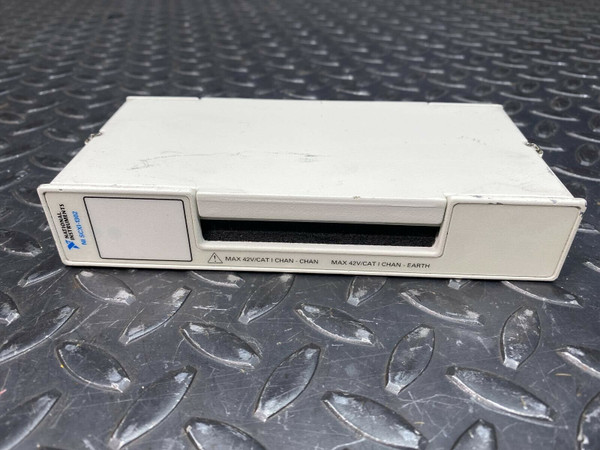 A National Instruments NI SCXI-1302, 50-Pin Terminal Block from Obtainium Science and Surplus, shown from a front angle view. The device is placed on a textured metal surface.