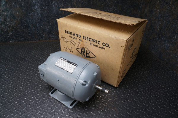 Reuland 6610 torque motor rated for 208VAC, 3-phase, 60 Hz, with a locked torque of 1 foot-pound and a 3/4-inch shaft from Obtainium Science and Surplus, shown next to its original cardboard shipping box from Reuland Electric Co.
