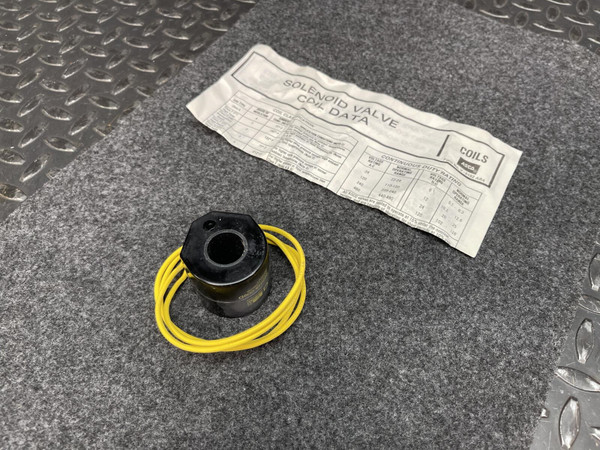 Black ASCO solenoid coil with coiled yellow lead wires beside the coil data sheet
