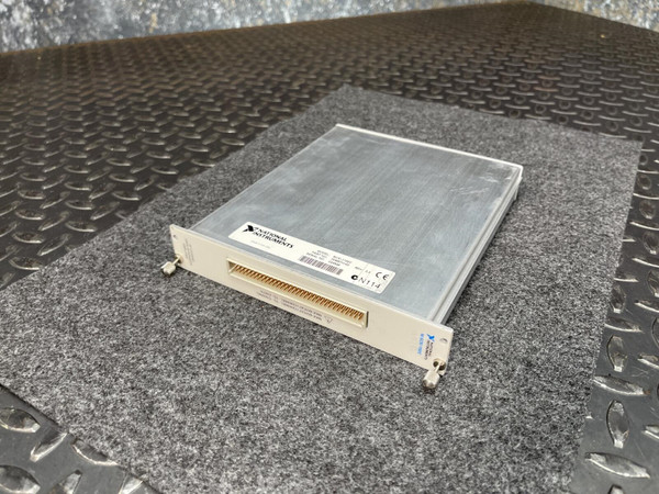 Brushed aluminum top cover with light surface marks; white faceplate with NI logo label and dense gold-pin connector strip visible.