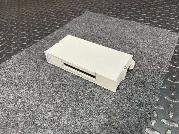 Off-white plastic enclosure with a front-facing card slot opening; minor surface marks consistent with normal use. Mounting latch visible on right side.