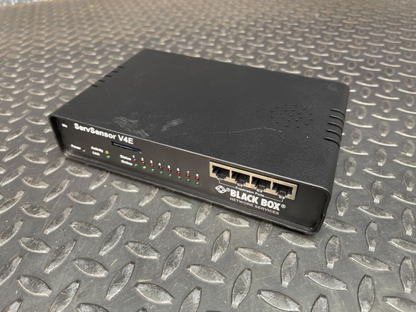 Black Box ServSensor V4E unit on a metal surface, showing front panel with status LEDs, four expansion ports, and logo.