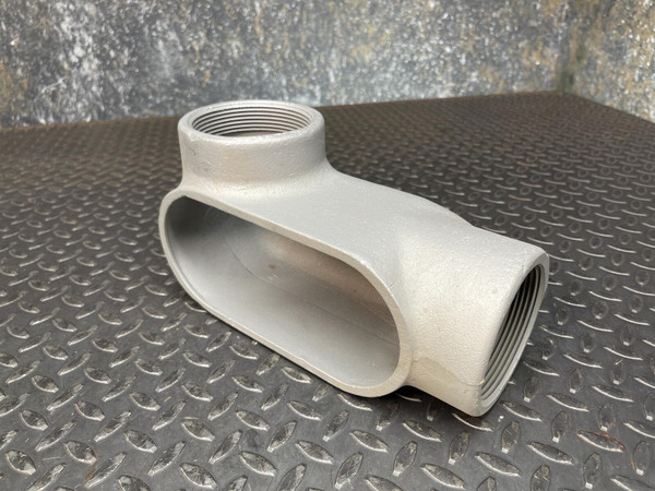 A 3-inch Appleton LL conduit body from Obtainium Science and Surplus, viewed from an angle, showing its gray metallic surface and oval opening.