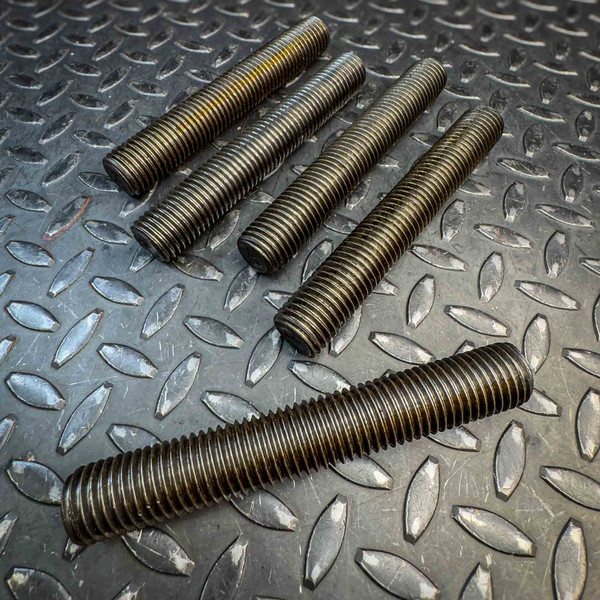 Five black Threaded Rod / All Thread Studs from Obtainium Science and Surplus, placed on a textured metal surface.