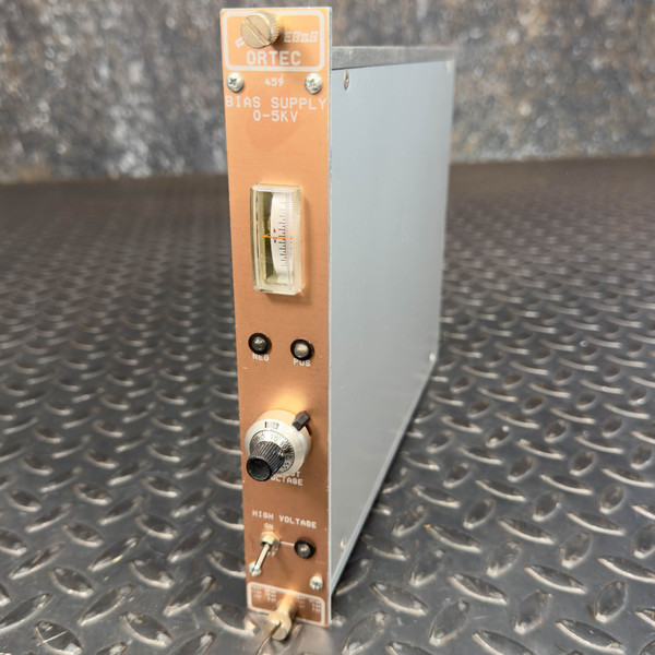 A front-angle view of an Ortec 459 Adjustable HV Bias Power Supply Nuclear Instrumentation Module from Obtainium Science and Surplus. The module has a metallic body with a copper-toned front panel, featuring a dial and two indicator lights labeled NEG and POS. The panel includes a high voltage control knob and a gauge displaying voltage levels ranging from 0 to 5kV.