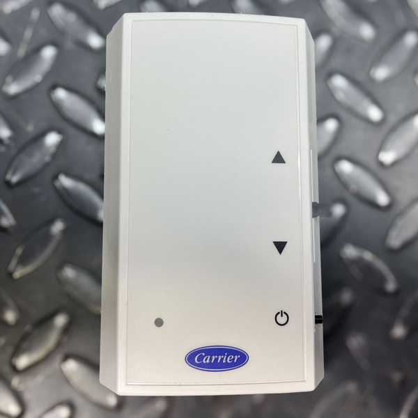 White Carrier iVu ZS Plus Sensor (ZSPLCAR) for HVAC zone control, a sleek rectangular device featuring up/down arrow buttons, a power button, a small indicator light, and the blue oval Carrier logo at the bottom, photographed against a dark grey industrial diamond plate background. This modern room sensor provides precise temperature and fan control for commercial building automation systems.