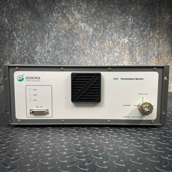 Front view of a LumaSense Innova 1313 Fermentation Monitor Analyzer, offered for parts. The grey rackmount style unit features a white front panel displaying the Innova AirTech Instruments logo and "1313 Fermentation Monitor" text. Visible details include power, sensor, and alarm status indicator labels, a DB9 serial port connector, a prominent black square fan grille, and a metal quickconnect style fitting on the right side with labels for Particle Filter, Measurement, and Calibration inputs, highlighted by green lines. This scientific lab instrument is shown against a dark, textured background.