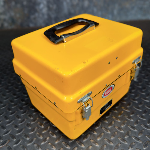 Angled view of the closed yellow case of the Biddle Megger Digital Ground Earth Tester from Obtainium Science and Surplus, with a black handle on top and side latches.
