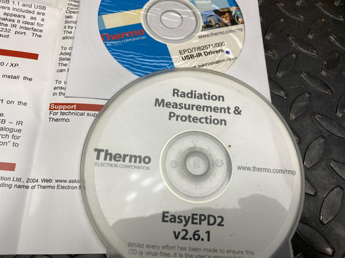 Close-up of CDs labeled "Radiation Measurement & Protection" and "EasyEPD2 v2.6.1" along with related paperwork from the Thermo ACT5 Dosimeter Reader for EPD Mk2, G, and N2 from Obtainium Science and Surplus.