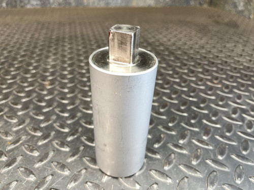 A Norbar Torque Transducer standing vertically, showing its square 3/4" drive at the top. The silver cylindrical body rests on a textured metal surface. This tool is part of the Obtainium Science and Surplus collection.