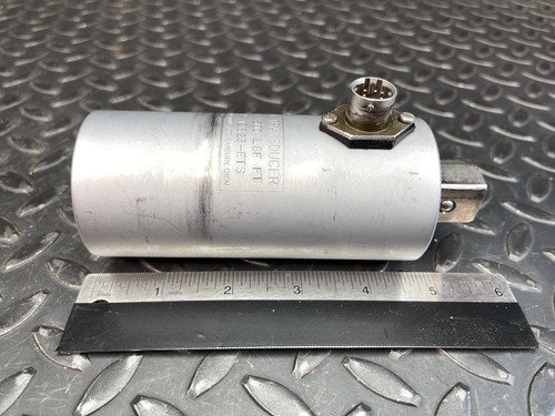 The Norbar Torque Transducer shown horizontally with its connector port and engraved details visible. The body rests at a slight angle on the textured surface, with the square drive extending from one end.