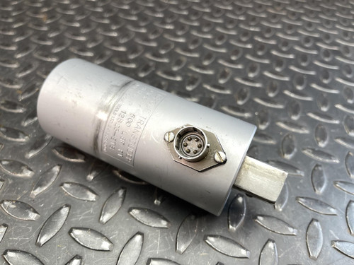 Close-up focus on the connector port of the Norbar Torque Transducer, revealing the metal pins inside. The surrounding body features part of the engraved specifications, with light wear marks on the silver finish.