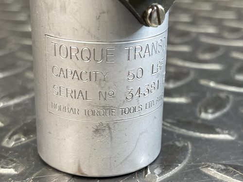 Close-up of the side view of the Norbar Torque Transducer 50 LBF·IN – 1/4" Drive from Obtainium Science and Surplus, showing engraved text with capacity and serial number.