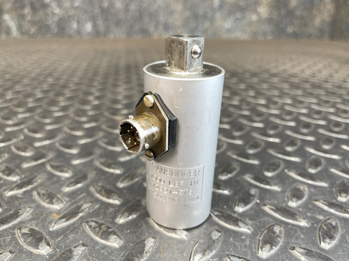 A Norbar Torque Transducer with 1000 LBF·IN capacity, featuring a cylindrical metal body with a 1/2-inch drive input/output, resting on a textured metal surface.