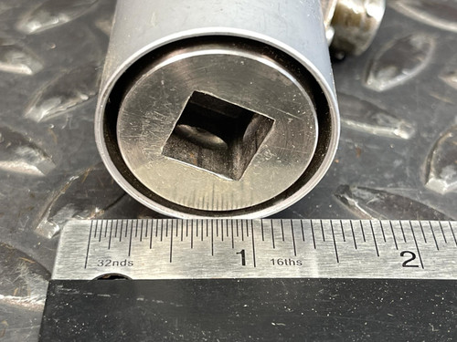 Close-up of the drive end of the transducer with a square opening, measured with a ruler placed alongside, indicating size precision.
