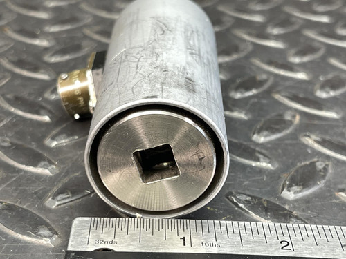 Norbar Torque Transducer 500 LBF·IN – 3/8" Drive In/Out, lying on its side with a square opening on the end, accompanied by a ruler for scale. The background features a textured metal surface.