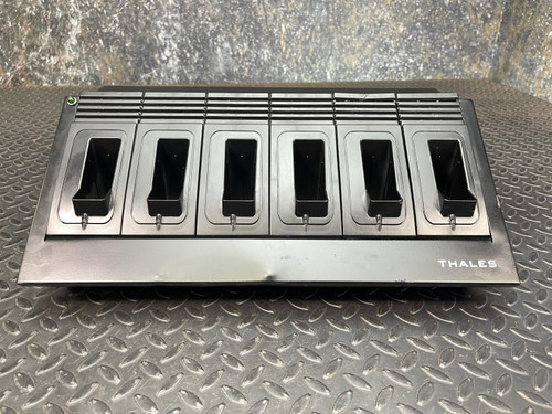 A Thales battery charger for MBITR tactical radios from Obtainium Science Surplus, shown on a metal surface with five charging slots visible.