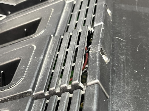 Close-up of the Thales battery charger for MBITR tactical radios from Obtainium Science Surplus, focusing on the ventilation grilles with visible internal wiring.