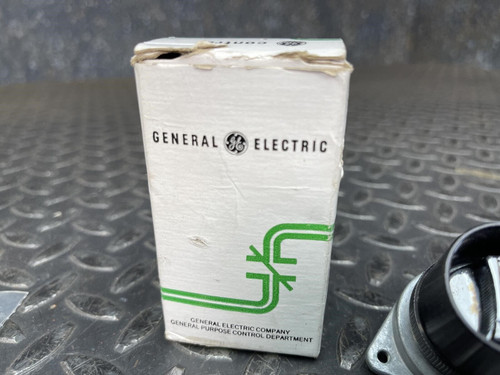 The side of the worn cardboard box for the GE 3-Position Oil-Tight Switch - Model CR2940UB200B from Obtainium Science and Surplus, featuring green arrows printed on the surface.