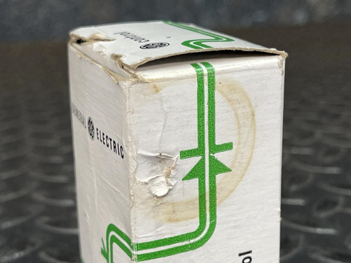 A close-up of the damaged corner of the cardboard packaging for the GE 3-Position Oil-Tight Switch - Model CR2940UB200B, with wear and discoloration visible.