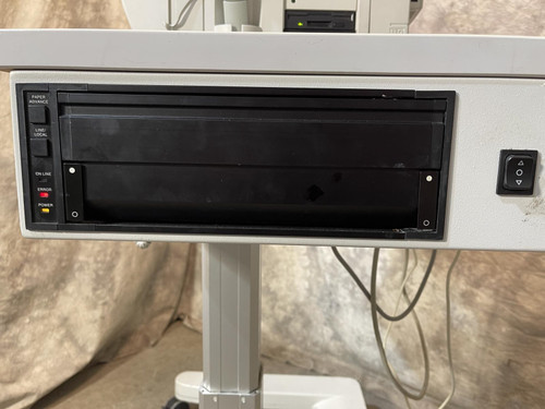 A zoomed-in image of a printer on the Carl Zeiss Meditec Humphrey Visual Field Analyzer 750i, featuring a black compartment with control buttons.